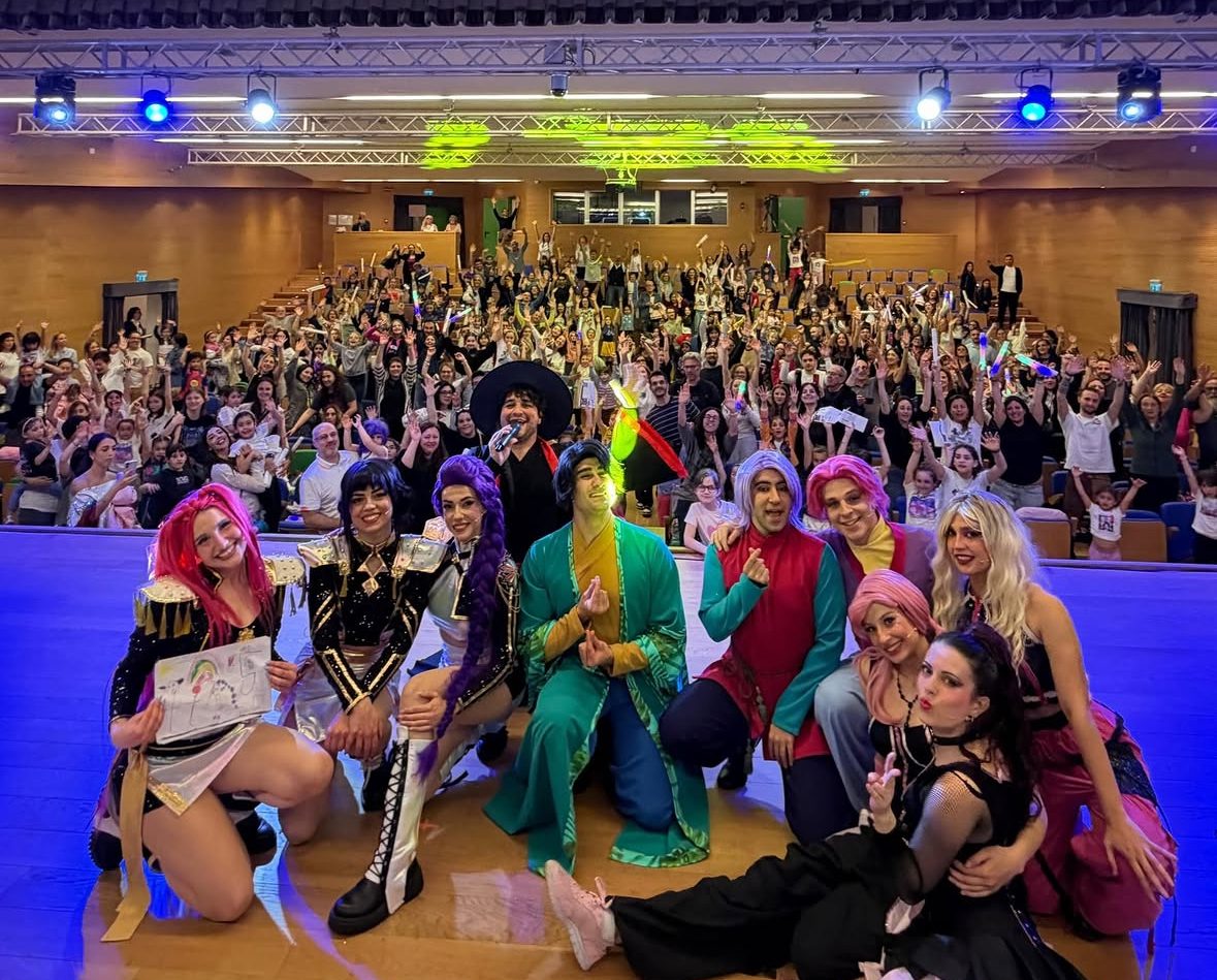 Il cast del K-POP Crazy Party Show sul palco con il pubblico in festa e i lightstick accesi